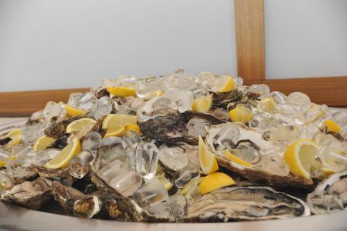 a pile of oysters and lemon slices on a plate at Hotel Astoria in Fermo