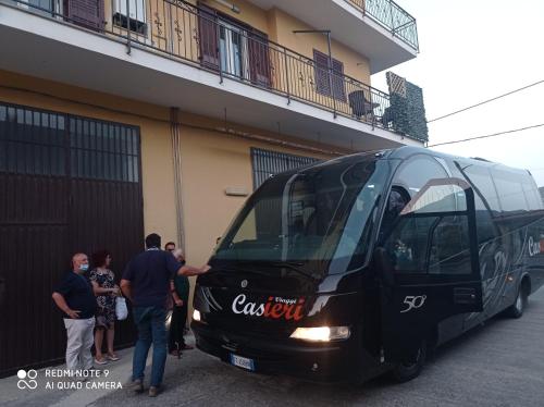 a group of people standing next to a black bus at B&B Albachiara in Senise