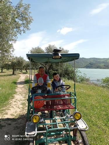 a man and two children riding on a golf cart at B&B Albachiara in Senise