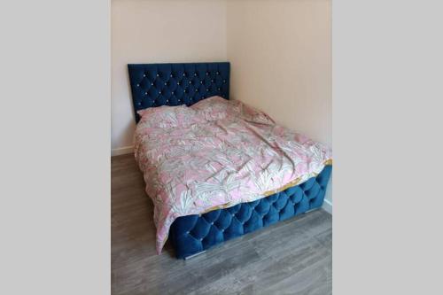 a bedroom with a blue bed in a room at Spacious one bedroom family apartment -non smoker in Wakefield