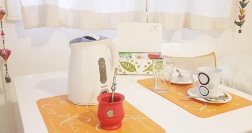 a table with a coffee maker and cups on it at Porteño 7 Hospital Italiano in Buenos Aires