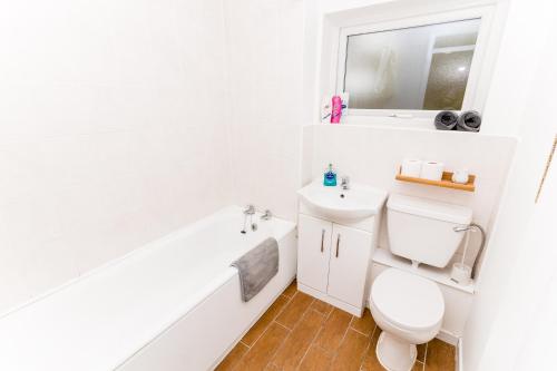 La salle de bains blanche est pourvue de toilettes et d'un lavabo. dans l'établissement Cosy City Centre Apartment With Parking, à Norwich