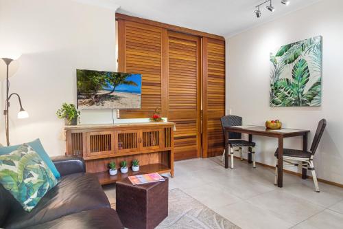 a living room with a couch and a table at Hibiscus Resort 10 ~ Fabulous location in Port Douglas