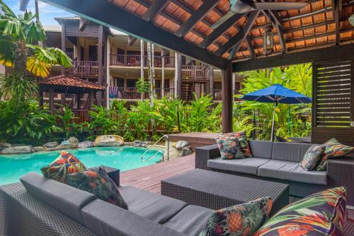 an outdoor patio with furniture and a swimming pool at Hibiscus Resort 10 ~ Fabulous location in Port Douglas