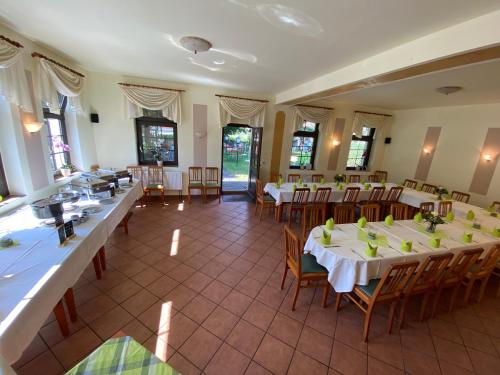 uma sala com mesas e cadeiras num restaurante em Kastanienhof em Müglitztal