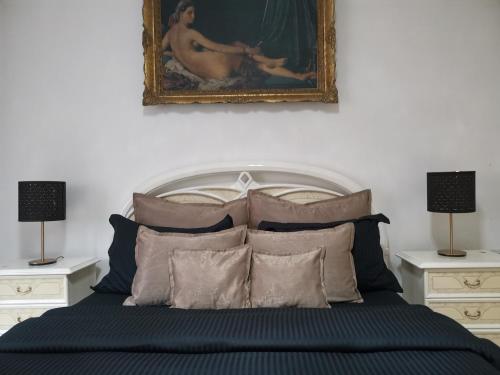 a bedroom with a bed with a painting on the wall at Apartments & Pool Villa White House in Pančevo