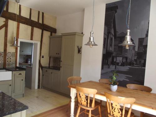 a kitchen with a wooden table and chairs at The Old King's Head with free parking in Hastings