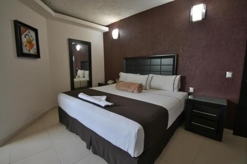 a bedroom with a large bed in a hotel room at Hotel Portonovo Plaza Guadalajara in Guadalajara