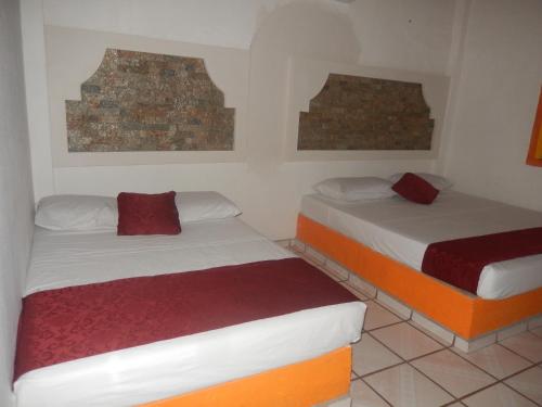 two beds in a small room with two at Lizmar in Los Ayala