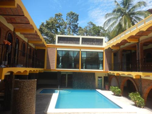 a building with a swimming pool in front of it at Lizmar in Los Ayala