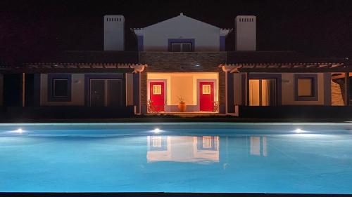 a house with a swimming pool at night at Ares do Monte - Turismo Rural in Cercal
