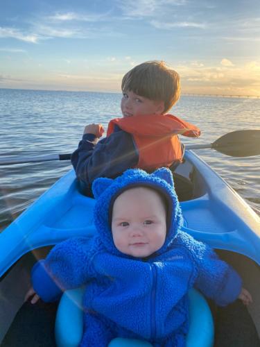 two young boys sitting in a boat on the water at Newly Renovated Confederation Bridge View Cottages in Borden