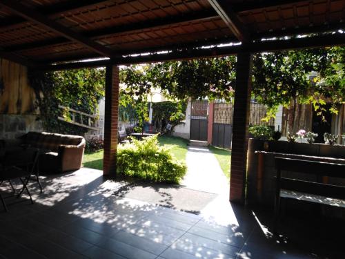 an outdoor patio with a pergola and a yard at Hospedaje Lolita in San Pedro La Laguna