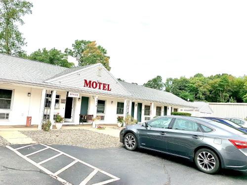 a car parked in a parking lot in front of a motel at Nitey Nite Motel in South Windsor