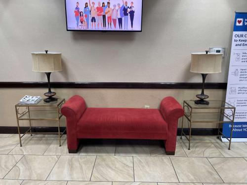 a red couch in a waiting room with two lamps at Best Western Richmond Hotel in Richmond