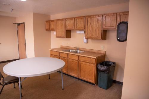 uma cozinha com uma mesa branca e um lavatório em wagner lakeside motel em Wagner