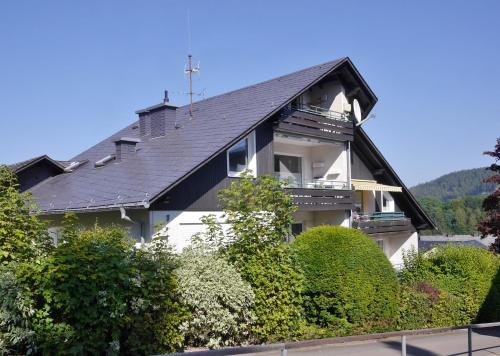 a large white house with a black roof at Fewo Steingrotte (inkl. MeineCard+) in Willingen