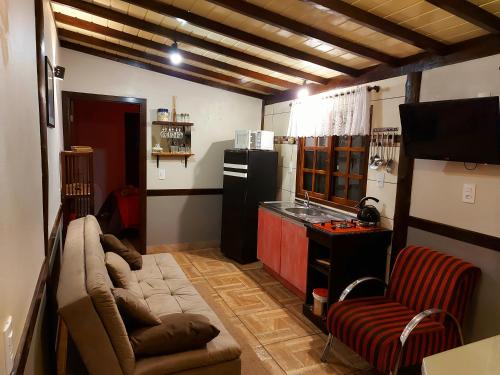 uma sala de estar com um sofá e uma cozinha em Recanto Pôr do Sol em Nova Petrópolis