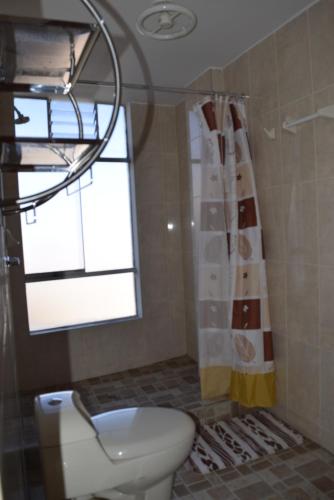 a bathroom with a toilet and a window at Marlon's House Puno-Peru in Puno