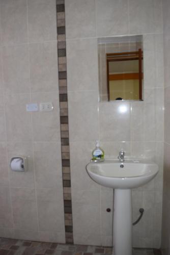 a bathroom with a white sink and a mirror at Marlon's House Puno-Peru in Puno