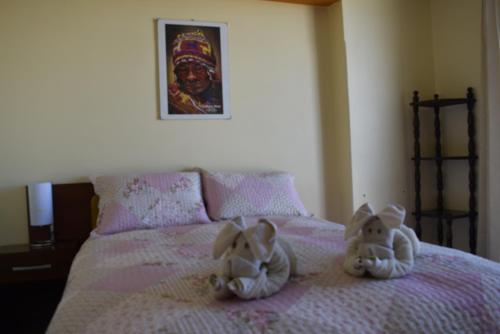 two stuffed animals sitting on top of a bed at Marlon's House Puno-Peru in Puno
