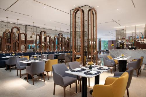 a restaurant with tables and chairs and mirrors at voco Nanjing Oriental Pearl in Nanjing