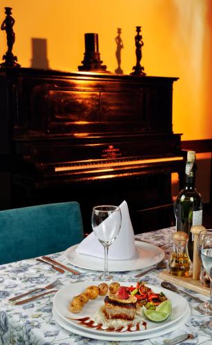 a table with a plate of food and a piano at Hotel Boyaca Plaza in Tunja