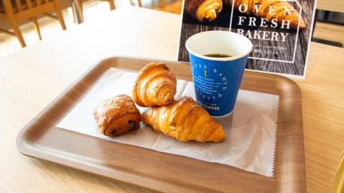 a tray with two croissants and a cup of coffee at UNIZO INN Express Utsunomiya in Utsunomiya