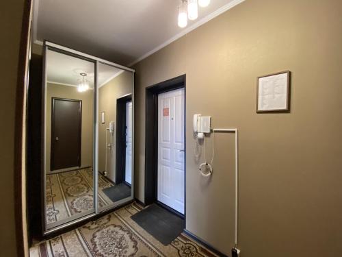 a hallway with a bathroom with a door and mirrors at Dekabrist apartment at Ugdanskaya 8 in Chita