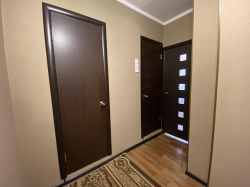 an empty hallway with two doors and a rug at Dekabrist apartment at Ugdanskaya 8 in Chita
