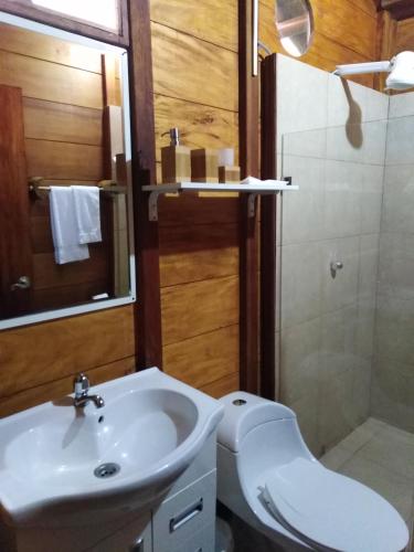 a bathroom with a sink and a toilet and a shower at Estancia La Colina in Santo Domingo de los Colorados