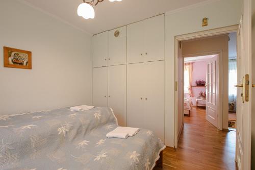 a white bedroom with a bed and a closet at Całoroczny dom wakacyjny in Stęszewko