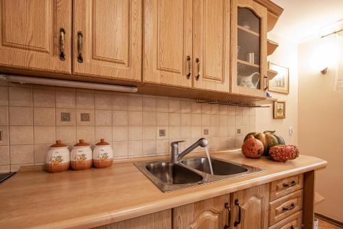 a kitchen with wooden cabinets and a sink at Całoroczny dom wakacyjny in Stęszewko