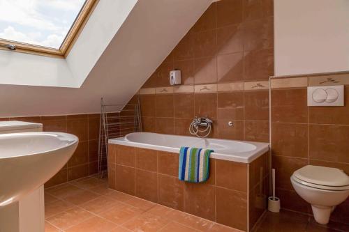 a bathroom with a tub and a toilet and a sink at Gozsdu Court Budapest in Budapest
