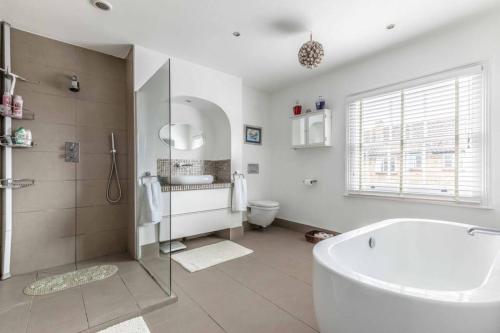 a bathroom with a tub and a sink and a toilet at Windsor Town Centre Victorian townhouse sleeps 6 in Windsor