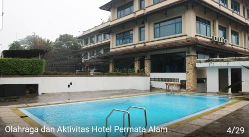 a swimming pool in front of a building at Hotel permata alam in Bogor