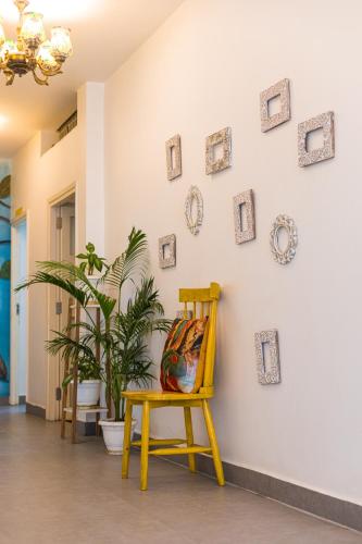 a yellow chair in a room with pictures on the wall at Stay Banaras - A Boutique Hotel in Varanasi