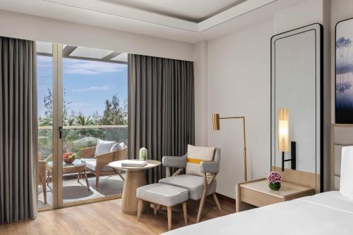 a bedroom with a bed and a living room at Vivanta Goa, Miramar in Panaji