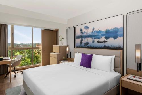 a hotel room with a large bed and a desk at Vivanta Goa, Miramar in Panaji