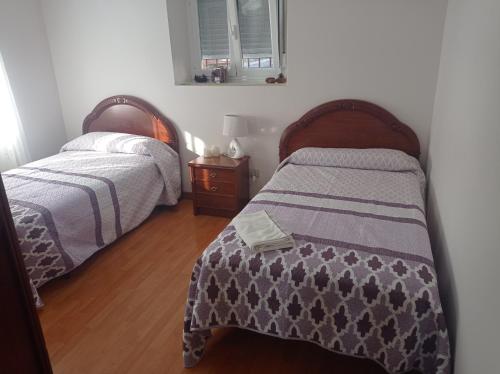 1 dormitorio con 2 camas y suelo de madera en Los Tres Hórreos, en Felechas