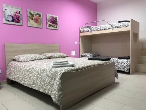 B&B La Casa di Violetta في Acconia: غرفة نوم مع سرير بطابقين وجدران أرجوانية