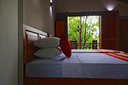 a bedroom with a bed with pillows and a window at The Hideaway in Kurunegala