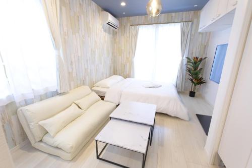 een woonkamer met een bank en een bed bij AQA ART 江の島 in Fujisawa