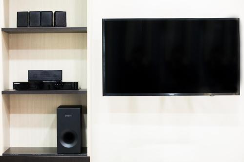 a flat screen tv sitting on a wall with a speaker at Rhodes Central Suite in Rhodes Town