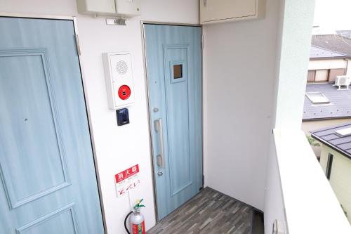 a hallway with two blue doors on a building at AQA ART 江の島 in Fujisawa