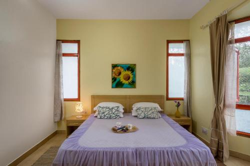 a bedroom with two beds with a tray on the bed at StayVista at Sunshine Estate Serene 2BR Pet Friendly Villa in Chail with view in Chail