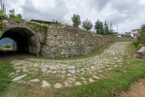 a stone wall with a tunnel and a bridge at StayVista at Sunshine Estate Serene 2BR Pet Friendly Villa in Chail with view in Chail