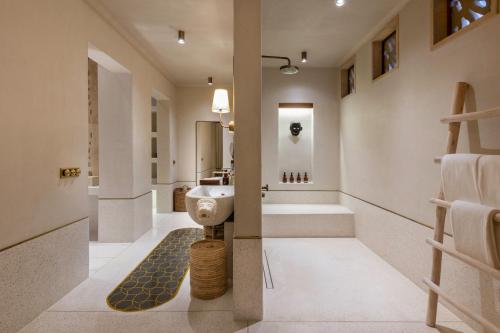 薩桑吉爾的住宿－Aramness Gir National Park，浴室配有卫生间、盥洗盆和浴缸。