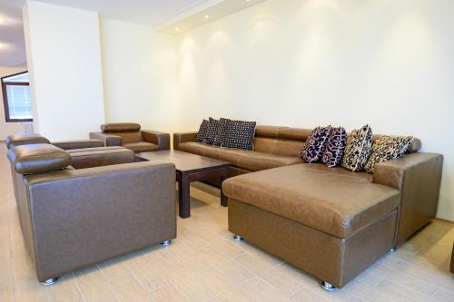 a living room with couches and a table and a couch at Parklands Hotel & Pool in Bansko