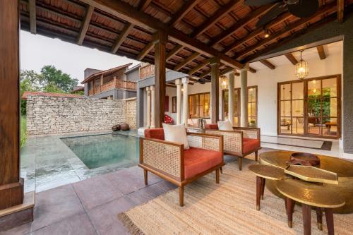 an outdoor patio with a pool and chairs and a table at Aramness Gir National Park in Sasan Gir